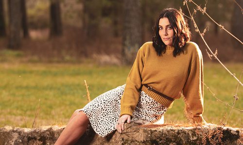 Young woman wearing a yellow sweater and animal print skirt