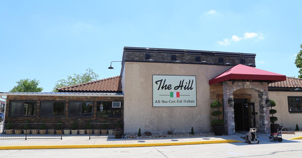 Stucco restaurant with outdoor dining and red awning