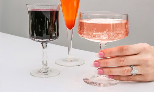 woman's manicured hand with three cocktails