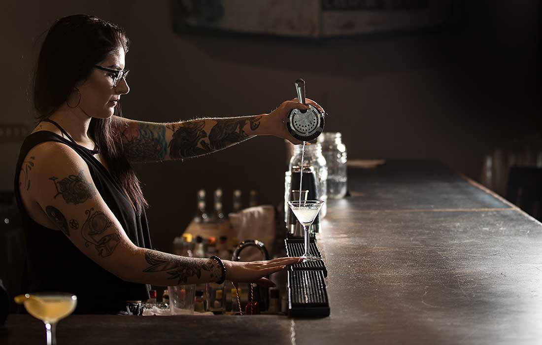 The bar tender pours the final toper on the Gin Gardens drink