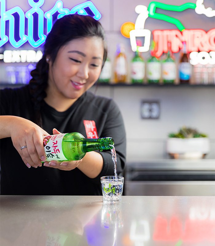 woman pouring a drink at a bar