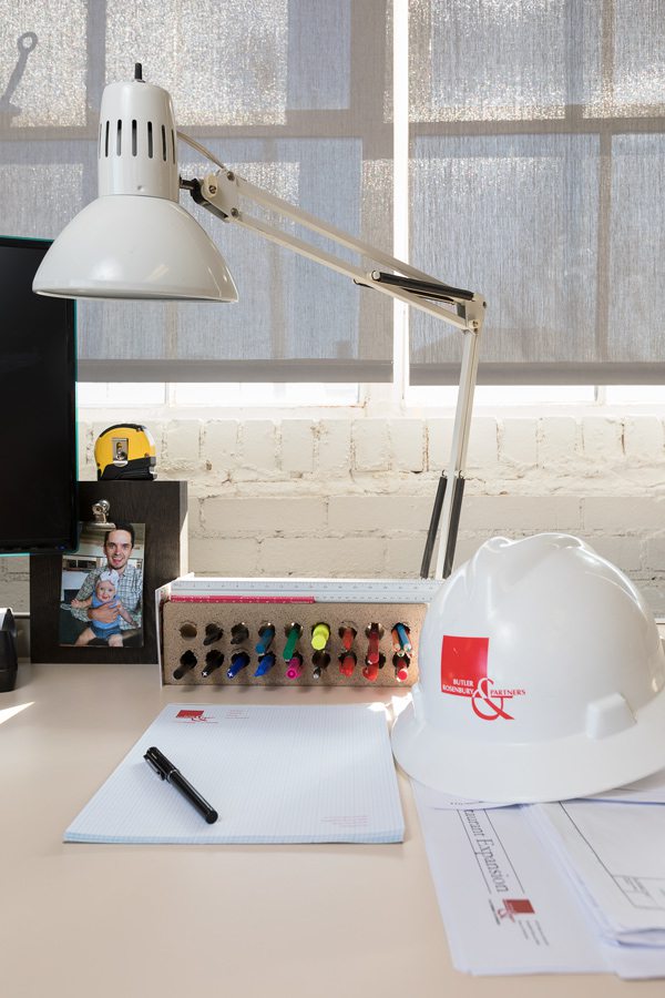 Hard hat on bright modern desk with lamp