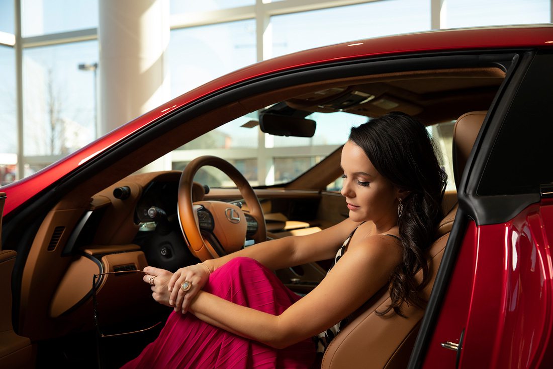 Jewelry by Mitchum Jewelers in Ozark MO; Hot pink skirt and glasses at Apricot Lane in Springfield MO;  Leopard one piece by Nixa Clothing Company in Nixa MO. Shot at Reliable Lexus in Springfield MO.