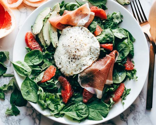 breakfast salad with prosciutto and a fried egg
