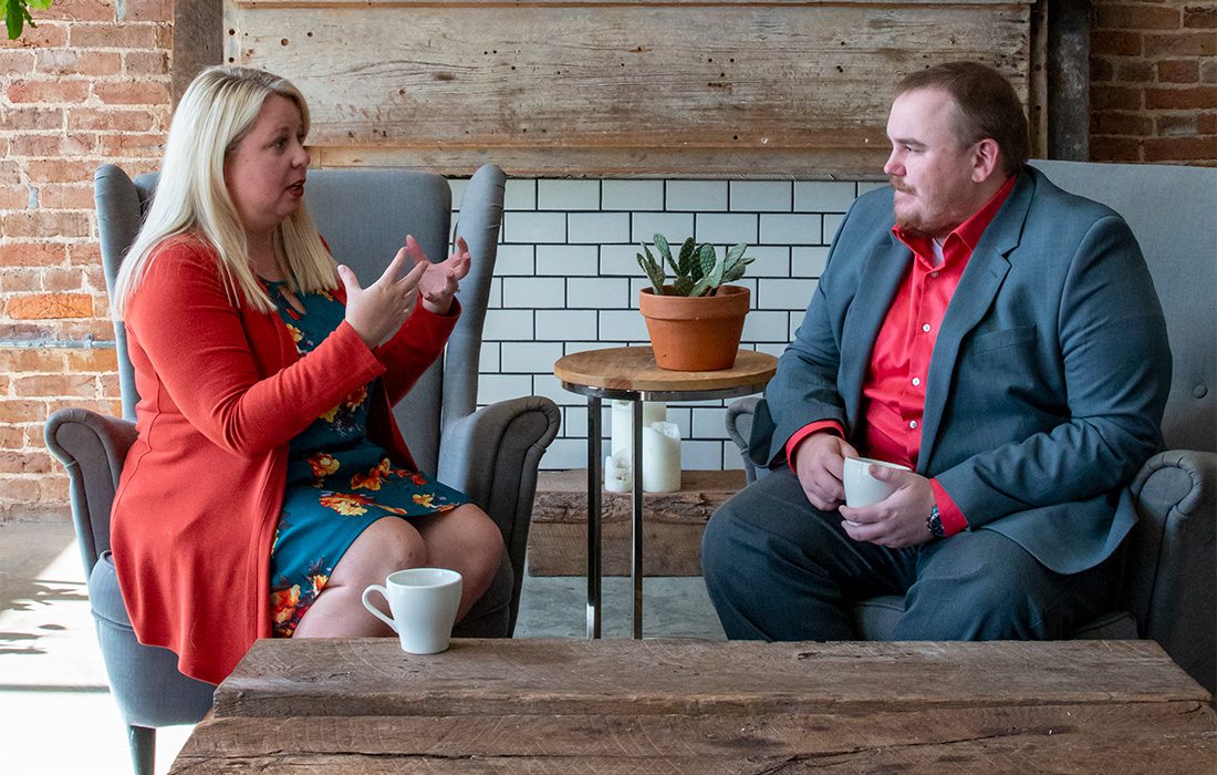 Marissa LeClaire Weaver and Ryan Gipson talking on a couch in springfield missouri