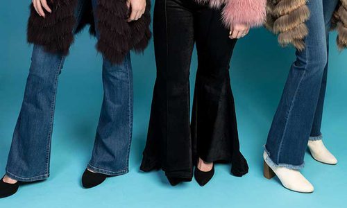 legs of three women wearing bell bottom jeans and booties