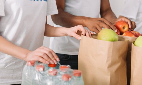 Stock image of volunteers with food donations