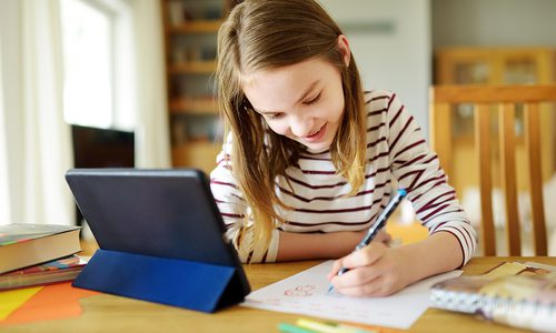 Stock image of young girl taking an online class