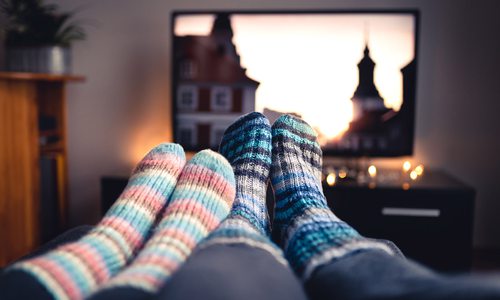 Couple streaming TV together stock photo.